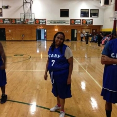 A participant smiling while posing on the basketball court.
