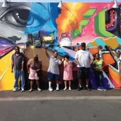 Participants wave in front of Coney Island Art Walls