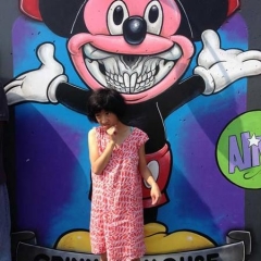 A participant stands in front of a graffiti of Mickey Mouse.