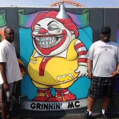 Two participants stand around a graffiti of Roland McDonald.