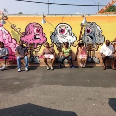 Participants sit in front of a graffiti wall.
