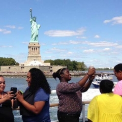 Participants taking selfie photos in front of Statue of Liberty.