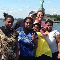 Participants pose for a group shot as the boat passes Statue of Liberty.