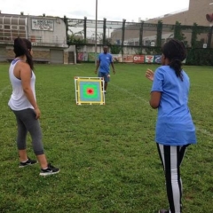 A participant throwing a ball at a bullseye.