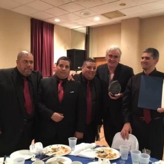 Los Ciegos Del Barrio pose with the award and Eliott Osborne, their mentor.