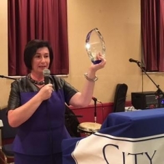 Sophia Rossovsky, City Access New York Executive Director, is holding up the crystal award.