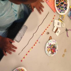 A participant in the middle of making a necklace.