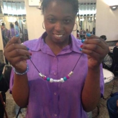 A participant holding up a necklace.