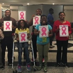 Participants holding up pink ribbons.
