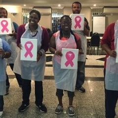 Participants holding up pink ribbons.