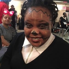 A participant with a painted face smiles at the camera.