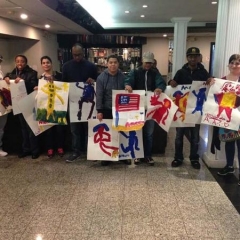 Participants pose with art work they created during an art session.