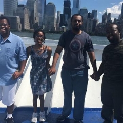 Participants holding hands in front of the New York skyline.