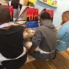 Participants in the middle of painting the New York skyline.
