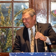 Bob Bentson, gala honoree, accepts an award.  ID: Bob smiles at the podium.