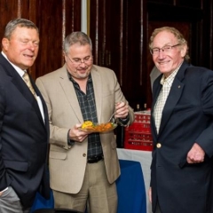 Bob Bentson and friends.  ID: The men stand sampling hors d'oeuvres.