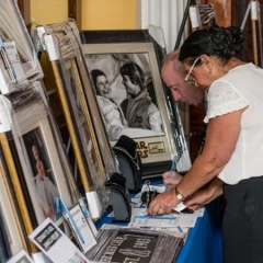 Display of silent auction items.  ID: Two people placing bids for the auction.