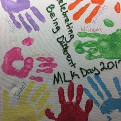 Art painting with different color hand prints to symbolize our differences.