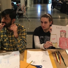 A participant holding up her drawing of an artist.