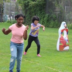 Two participants racing.  ID: Participants wearing pink and lavendar color shirts.