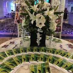 Golf outing brochures lined up in front of a bouquet of flowers.
