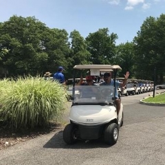 Event participants riding in a golf cart.