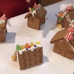 Ginger bread houses made by Day Habilitation participants.  ID:  Ginger bread houses on a white cloth.