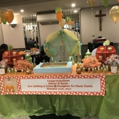 A table with a Halloween display.  ID: The table is decorated with  balloons and Halloween inspired deserts.
