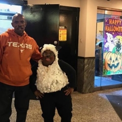Two participants pose for a picture.  ID: The participant on the right is wearing a lamb costume.