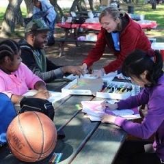 Participants drawing.  ID: Several participants sitting at a table and making drawings.