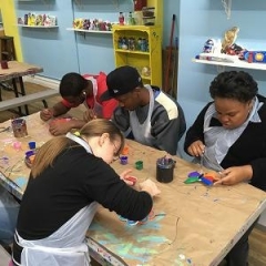 Participants paint various clay figures.