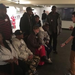 The group listens to the guide at the Transit Museum.
