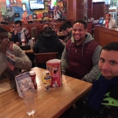 Participants enjoying lunch after a visit to the Liberty Science Center.  ID: Three participants sitting at a table.