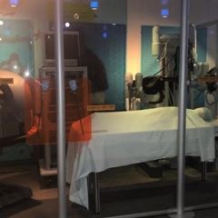 A robotics display at the Liberty Science Center.  ID: A representation of a hospital room with various robotics to handle patient care.