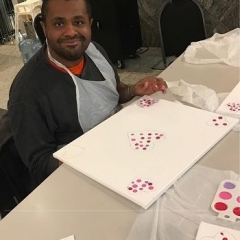 Participant finger painting a Valentine's day inspired artwork.
