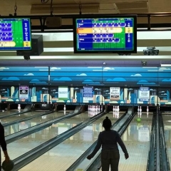 Rab’s Country Lanes in Staten Island.  ID: An attendee throws a ball down a lane.