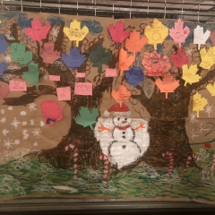A mural made by City Access Participants.  ID: Colorful leafs with a snowman in the center.
