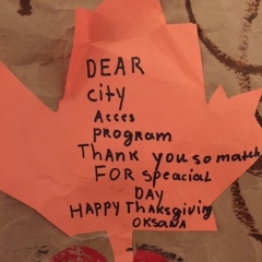 An orange paper leaf handwritten by City Access participant as part of a larger mural.  ID: The leaf reads: Dear City Access Program.  Thank you so much for special day."
