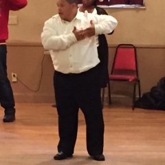 A participant during a dance performance.  ID: Participant is wearing a white shirt.