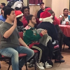 Participants in the audience clap for those that just performed.  ID:  Participants sitting around and watching the performance.