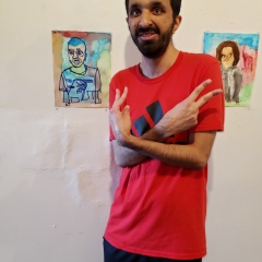 A participant poses next to his self portrait.