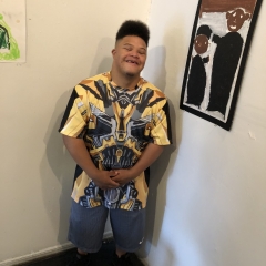 A participant poses next to his self portrait.
