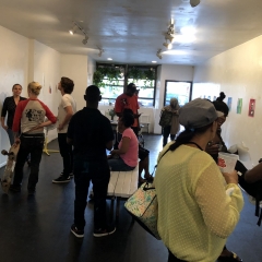 Visitors mingle at The Living Gallery while viewing self portraits of the City Access New York participants.