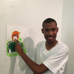 A participant poses next to his self portrait.