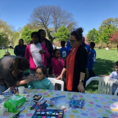 A little girl is having her face painted during City Access New York  2nd Annual Beeping Egg Hunt.