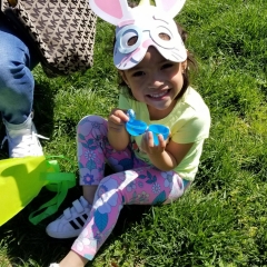 A little girl wearing a bunny mask hold an open Easter egg she found during the Beeping Egg Hunt event.