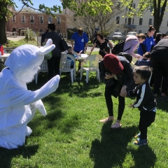 A little kid is being introduced to the Easter Bunny.