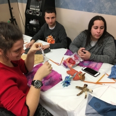 Participants working on an art project.  ID: Sitting around a table with art supplies.