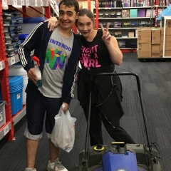 Two participants smile for the camera while working at Staples.