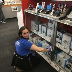 Participant cleaning a glass display while working at Staples.